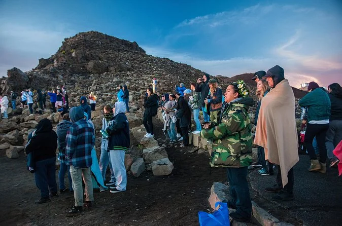 Visitors wrapped in blankets and jackets waiting at the summit before sunrise
